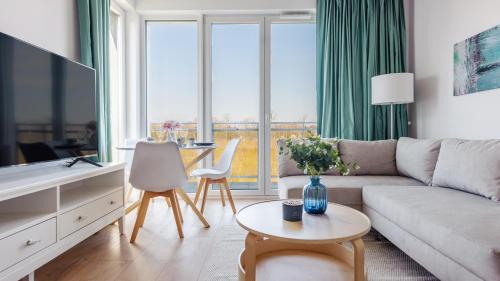 a living room with a couch and a table at Nexo, Sun & Snow in Puck