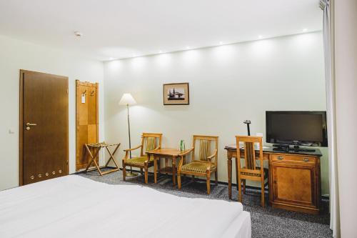 a hotel room with a bed and a tv and a table and chairs at Solaris in Toruń