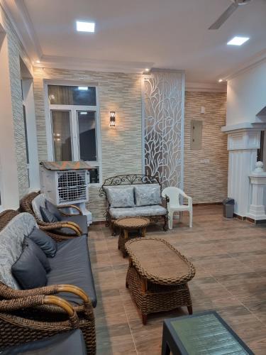 a living room with couches and wicker chairs at سمارت شاليه: Smart Chalet in Salalah