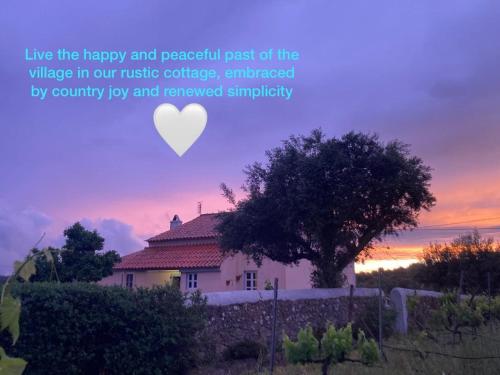 a white house with a tree and a heart at Linhal das Meias - São José das Matas in São José