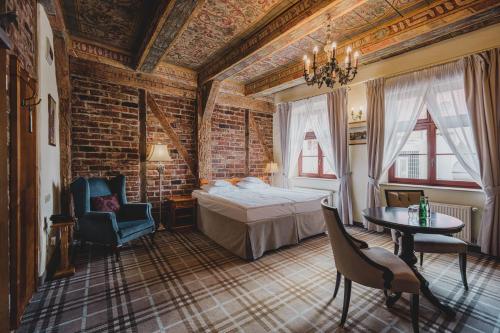 a bedroom with a bed and a brick wall at Solaris in Toruń