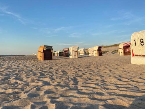 a row of beach huts on a sandy beach at Küstenapartment 3 in Gelbensande