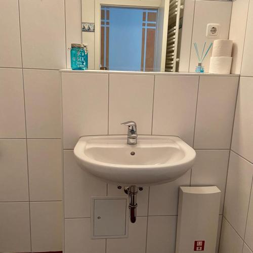 a white sink in a bathroom with a mirror at Küstenapartment 3 in Gelbensande