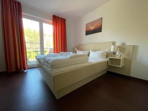 a bedroom with a large bed and a window at Küstenapartment 3 in Gelbensande