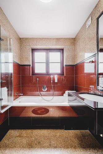 a large bathroom with a tub and a sink at Hotel Solaris in Toruń