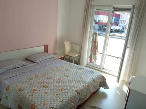 1 dormitorio con cama y ventana grande en Apartman Best, en Doboj