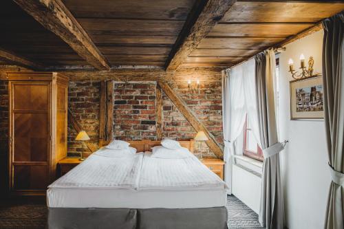 a bed in a room with a brick wall at Hotel Solaris in Toruń