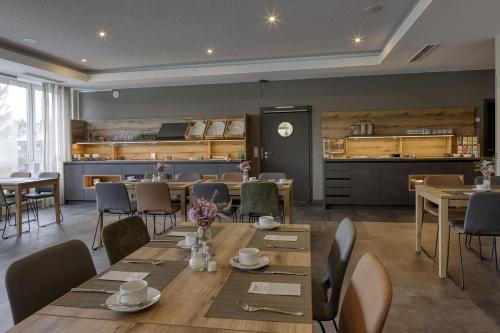 una sala da pranzo con tavoli e sedie e una cucina di Hotel Imhof a Gemünden