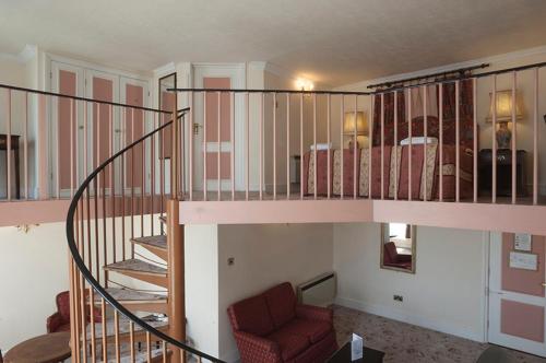 a room with a staircase with a couch and a bed at Royal Victoria Hotel in Hastings