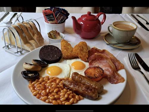 a plate of breakfast food with eggs bacon and beans at Bird In Bush Elsdon in Elsdon