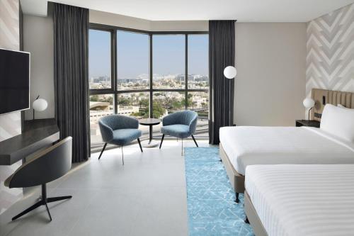 ein Hotelzimmer mit 2 Betten und einem TV in der Unterkunft Courtyard by Marriott World Trade Centre, Dubai in Dubai