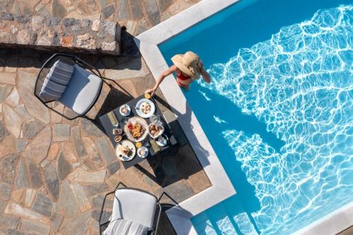 een tafel met eten naast een zwembad bij Searocks Exclusive Village in Kalamata
