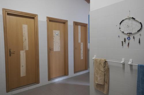 a bathroom with three doors and a clock on the wall at Rifugio Valomagna in Falciano