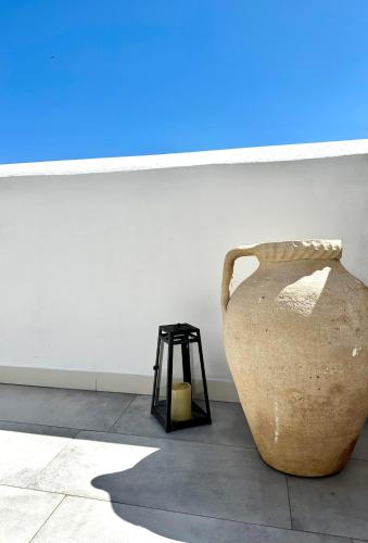 a large vase sitting next to a wall with a stool at Dimora delle Tonnare in Favignana
