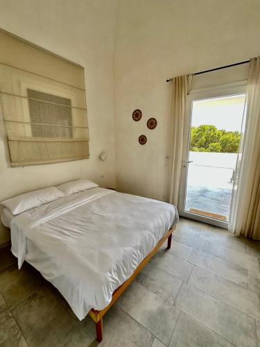 a bedroom with a large bed and a large window at Dimora delle Tonnare in Favignana