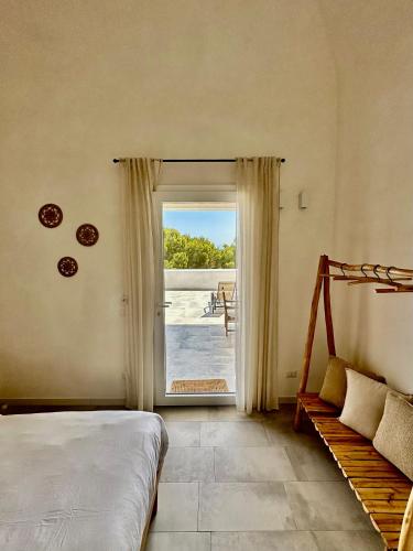 a bedroom with a bed and a sliding glass door at Dimora delle Tonnare in Favignana