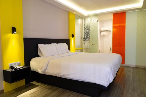 a bedroom with a large white bed and colorful walls at Hotel Z zpaze in Bangkok