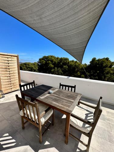 a wooden table and two chairs on a patio at Dimora delle Tonnare in Favignana