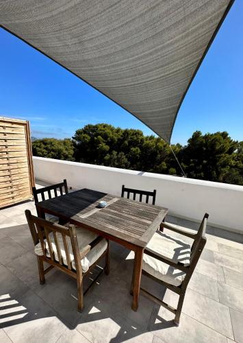 a wooden table and two chairs on a patio at Dimora delle Tonnare in Favignana