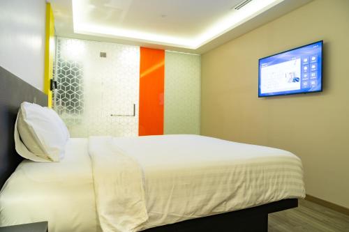 a bedroom with a bed and a tv on the wall at Hotel Z zpaze in Bangkok