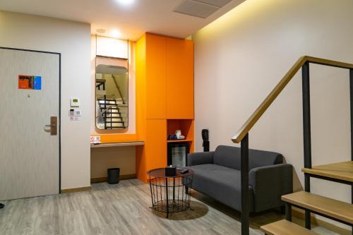 a living room with a couch and a staircase at Hotel Z zpaze in Bangkok