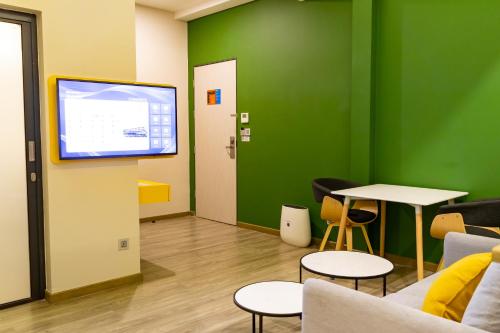 a room with a tv and a table and chairs at Hotel Z zpaze in Bangkok