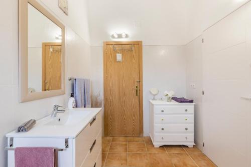 een badkamer met een wastafel en een houten deur bij Casa Buena Vista in Calnegre