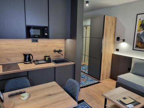 a small kitchen and living room with a table and chairs at ANIMA Bela reka C121, Brzeće in Brzeće