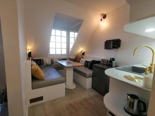 een woonkamer met een bank en een tafel in een kamer bij Magnifique cocon vue mer in Trouville-sur-Mer