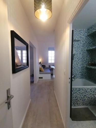 une salle de bain avec une baignoire, un lavabo et un miroir dans l'établissement Magnifique cocon vue mer, à Trouville-sur-Mer