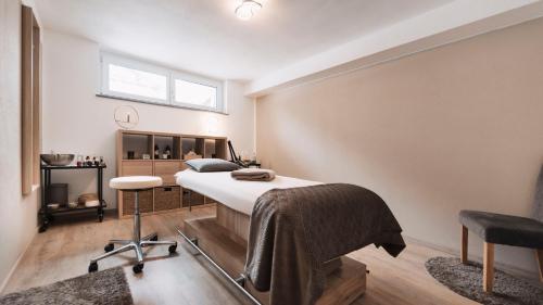 1 dormitorio con cama, escritorio y silla en Alpenflair en Berwang