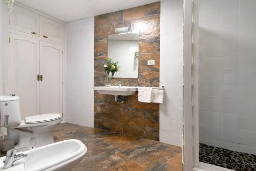 a bathroom with a toilet and a sink and a mirror at El Altillo House in Moya