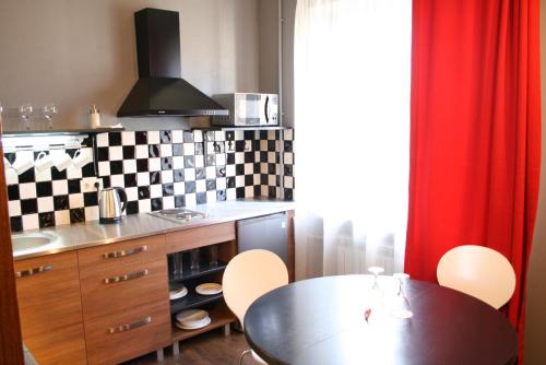 a kitchen with a table and a table and chairs at Aparthotel in Chişinău