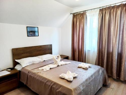- une chambre avec un lit et des serviettes dans l'établissement Pensiunea Filippo, à Mila Douăzeci şi Trei