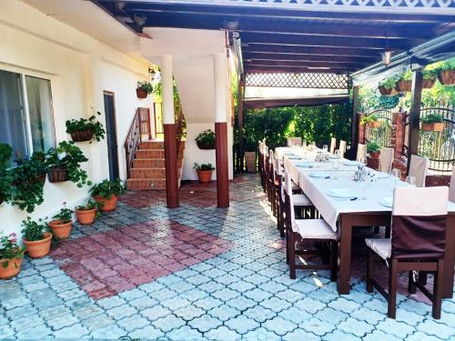 un restaurant avec une longue table sur une terrasse dans l'établissement Pensiunea Filippo, à Mila Douăzeci şi Trei