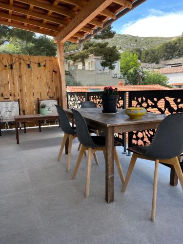 een houten tafel en stoelen op een patio bij Les nuits d'été Niolon in Le Rove