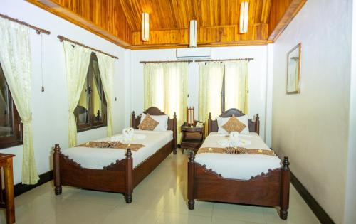 a bedroom with two beds in a room at Treasure Hotel Laos in Luang Prabang