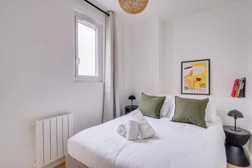 - une chambre blanche avec un lit blanc et des oreillers verts dans l'établissement La Casa 71 - Plein cœur de Bordeaux, à Bordeaux
