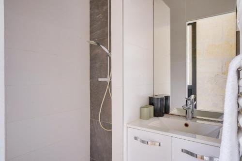 une salle de bain blanche avec une douche et un lavabo dans l'établissement La Casa 71 - Plein cœur de Bordeaux, à Bordeaux