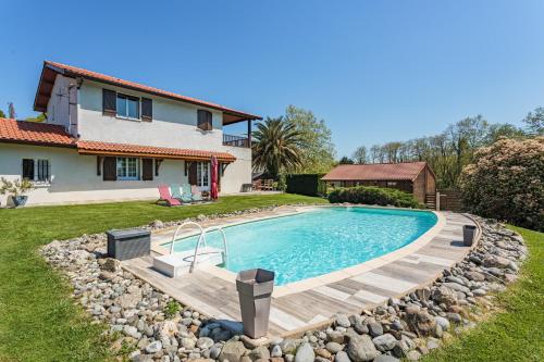 une piscine dans une cour à côté d'une maison dans l'établissement Maison Urt - Charmante maison avec piscine, à Urt