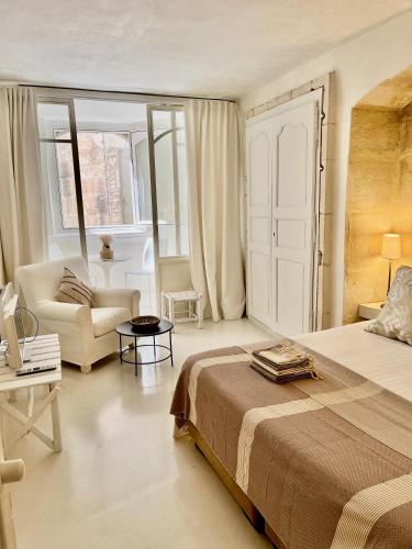 une chambre avec un lit, un canapé et une table dans l'établissement La Maison Plume, Appart Boutique, à Saint-Rémy-de-Provence