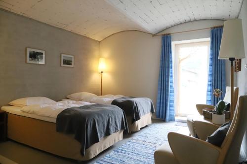 una camera d'albergo con due letti e una finestra di Landlig idyl på Dommergården Bed and Coffee a Læsø