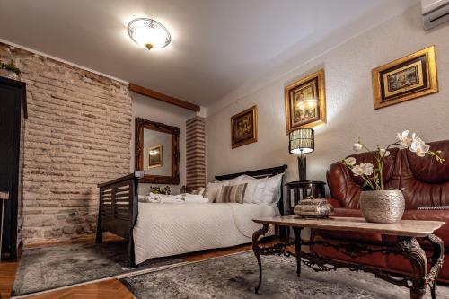 um quarto com uma cama, um sofá e uma mesa em Porta Orientalis em Split