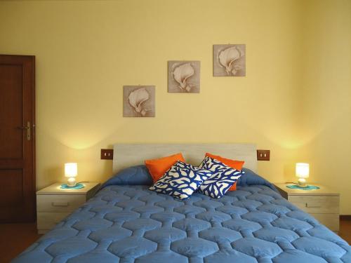 1 dormitorio con 1 cama azul y 3 cuadros en la pared en Dolci Sogni, en Pisa