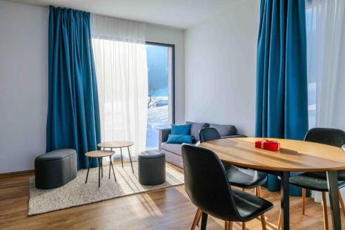 Hynčice pod Sušinou的住宿－Apartmány Trojice，客厅配有桌子和蓝色窗帘