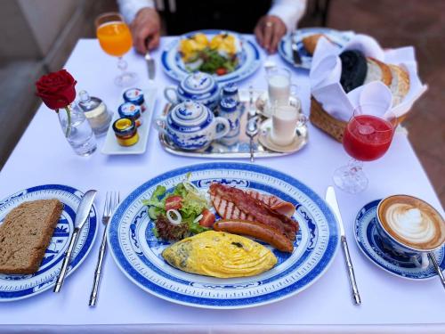a white table with plates of breakfast food on it at Rachamankha Hotel in Chiang Mai