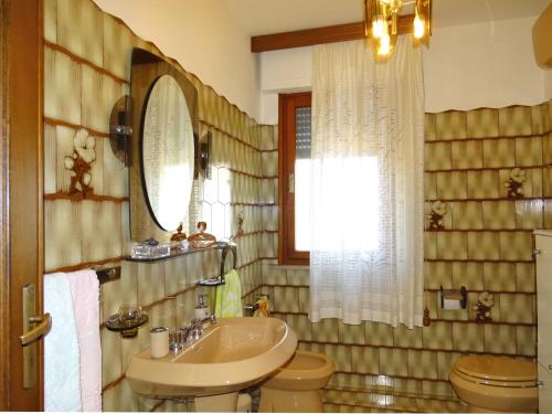 y baño con lavabo, aseo y espejo. en Dolci Sogni, en Pisa