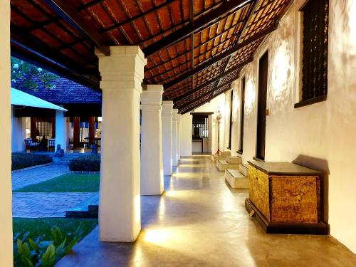 a hallway of a building with a wooden chest in the middle at Rachamankha Hotel in Chiang Mai