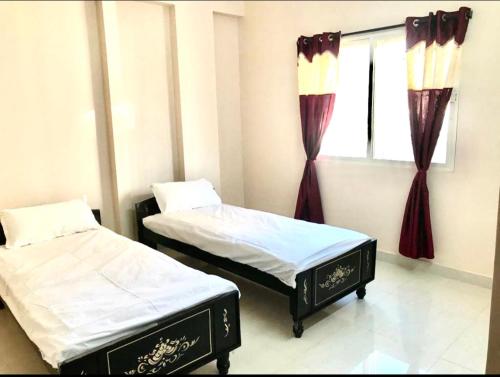 two beds in a room with a window at TheReefApartment in Hyderabad