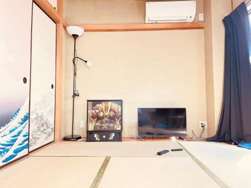 a living room with a flat screen tv and a room at 302东京中心全新装修宽敞明亮的公寓 3分钟步行路程到门前仲町站 两条地铁线直达东京上野新宿 in Tokyo